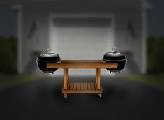 two bbq grills sitting on top of a wooden table in front of a garage