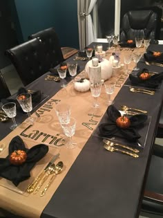 the table is set with black and gold place settings