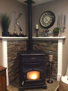 a wood burning stove sitting inside of a living room next to a clock on the wall