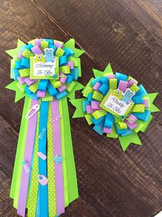 two colorful ribbons on top of each other sitting on a wooden table next to one another