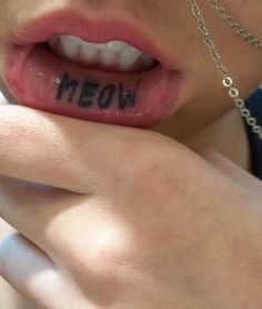 a woman with the word meon written on her lip is shown in close up