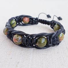 A stylish bracelet made from 10mm diameter Unakite jasper beads, braided with two cords (waxed and leather). Bracelet unisex will look great on your hand men and women or become an excellent gift.  Unakite jasper is a stone that encourages visionary abilities by opening your psychic vision. It works through the third eye chakra and aids you to visualize the things you desire in your life. This is one of the healing crystals that will assist better sleep, and will also help to relieve stress. It has an excellent balancing action for your emotions, bringing your emotions into line with your spiritual aspects. This is a lovely stone that is highly spiritual. Addictive habits that you have had difficulty dealing with, will be helped by its energy. It will give you help to break through the bar Bohemian Adjustable Leather Braided Bracelets, Adjustable Leather Braided Bohemian Bracelets, Adjustable Bohemian Braided Leather Bracelets, Adjustable Bohemian Leather Braided Bracelets, Handmade Leather Braided Bracelets, Adjustable, Handmade Adjustable Leather Braided Bracelets, Handmade Earthy Leather Bracelet With Adjustable Fit, Adjustable Leather Braided Bracelets, Adjustable Black Earthy Jewelry