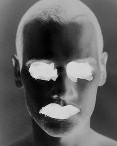 a black and white photo of a man with slices of cake on his face