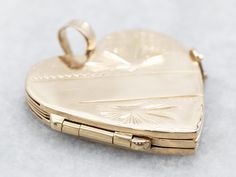 "This heart locket is crafted from 14-karat gold and features an etched design. A grooved finish inside the leaves creates a wonderful textural contrast to the polished surface of the heart.  This pendant would make a great romantic gift! This pendant does not come with the chain shown. Please feel free to contact us, we will help you find the perfect chain for your style and budget! Metal: 14K Yellow Gold Measurements: 31 x 26 mm, with bail Marks: \"14K\" Stamped on the reverse To view a video Gold Heart Locket, Gold Gift, Heart Locket, Romantic Gift, Locket Necklace, Gold Heart, Heart Jewelry, Heart Of Gold, Heart Pendant