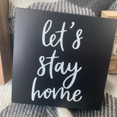 a black sign that says let's stay home