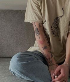 a person with tattoos sitting on a couch