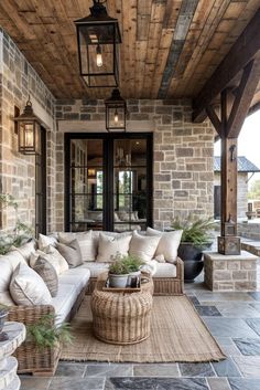 an outdoor living area with couches, tables and lamps on the ceiling is decorated in natural materials