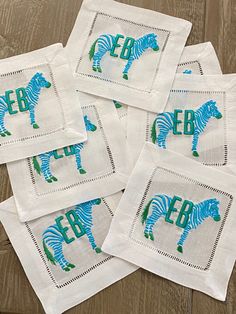 four zebra printed napkins sitting on top of a wooden table