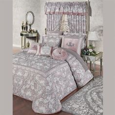 the bed is made up with pink and gray comforters