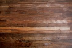 a close up view of a wood floor that has been stained brown and is peeling