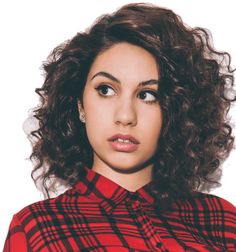 a close up of a person wearing a red and black plaid shirt with curly hair