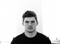 black and white photograph of a young man in a t - shirt looking at the camera