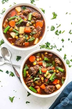 two bowls filled with beef and vegetable soup