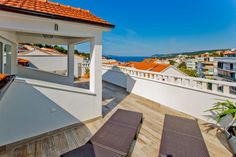 a balcony overlooking the ocean with lounge chairs