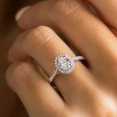 a woman's hand with a diamond ring on top of her finger and an engagement band