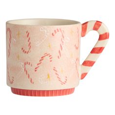 a cup with candy canes on it is sitting in front of a white background