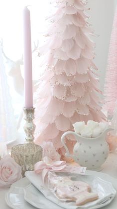 a pink christmas tree sitting next to a white plate