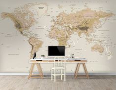 a desk with a computer on it in front of a large world map wall mural