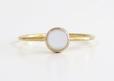 Simple, elegant and classic. This gold pearl ring is made from 14k gold filled material and set with a natural, mother of pearl stone. Each pearl is unique and natural. Whether you're buying this beautiful pearl ring as a gift or for yourself, it will bring forth new beginnings and good luck. Handmade in Los Angeles, CA!  Packaging:  Comes in a gift box, ready for gift-giving! Pearl Size: 5mm Band Size: 1 mm Material:  14k Gold Filled Benefits of 14k gold-filled jewelry: 1. Consists of solid gol Gold Moonstone Ring In 14k Gold, Adjustable 14k Gold Pearl Ring, Elegant Everyday White Opal Ring, Elegant Gold Moonstone Stackable Ring, White Elegant Everyday Opal Ring, Elegant Gold Stackable Moonstone Ring, Simple White 14k Gold Rings, White 14k Gold Rings With Simple Design, Minimalist Gold Opal Ring With Round Band