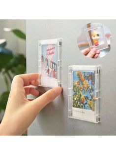 a hand is holding a plastic card holder with pictures attached to the back of it