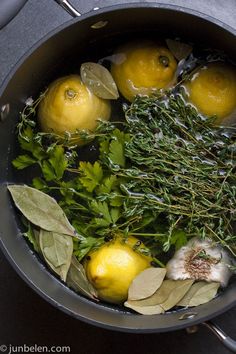 lemons and herbs are in a pan on the stove