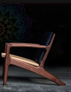 a wooden chair with black leather upholstered on the back and armrests