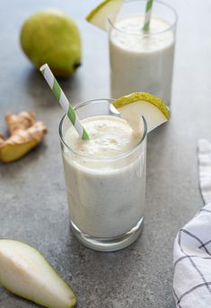 two glasses filled with smoothie next to sliced pears