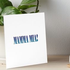 a white card with the word mamma on it next to a potted plant