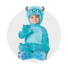 a child in a blue monster costume sitting on the floor with his hands up to his chest