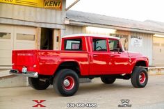 a red pick up truck parked in front of a building