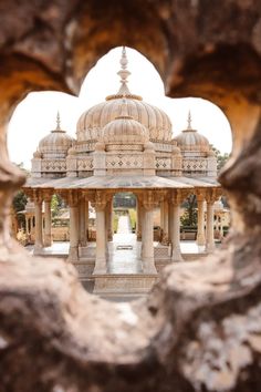 an ornate building seen through a hole in the wall