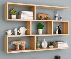 three wooden shelves on the wall with books, vases and figurines in them