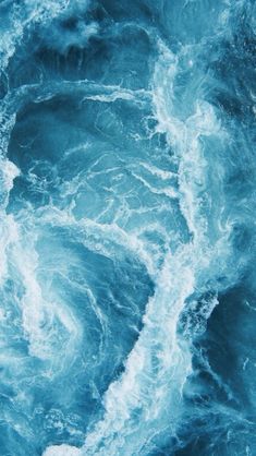 an aerial view of the ocean waves and foamy blue water with white foam on it