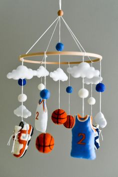 a mobile with basketballs, socks and shoes hanging from it's sides in the shape of clouds