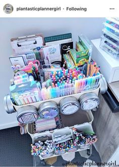 a cart filled with lots of different types of pens and pencils on top of a table