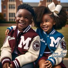 two young children sitting on the ground in front of a building smiling at the camera