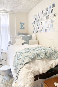 a bedroom with a bed, dresser and pictures on the wall