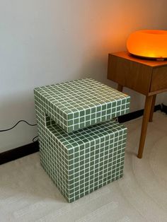 two stools sitting next to each other in front of a lamp