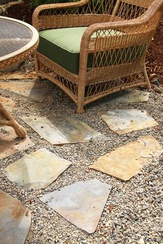 a wicker chair sitting on top of a stone floor next to a table and chairs