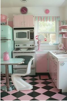 a pink and white kitchen with checkered flooring