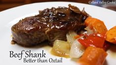 beef shank with carrots, onions and potatoes on a white plate that says beef shank better than oxtail