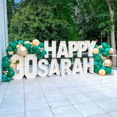 a large sign that says happy dosarah with balloons on the top and below it