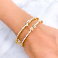 This exquisite set of 18k gold bangles, with a total weight of 40.7 grams, features an elevated twin flower design adorned with dazzling diamonds. The yellow gold finish enhances their luxurious appeal, making them perfect for any special occasion. Each bangle is set with a total diamond weight of 5.91 carats, featuring F-G color and VS quality diamonds in round brilliant cut shapes. With a bangle size of 2.5 and an opening diameter of 2.3 inches, these pieces offer both elegance and comfort. Id Elegant Flower Shaped Wedding Bangle, Gold Flower-shaped Cubic Zirconia Bracelets, Gold Cubic Zirconia Flower Bracelets, Gold Flower Bracelets With Cubic Zirconia, Twin Flower, 18k Gold Bangle, Diamond Bangle, Quality Diamonds, Gold Bangles