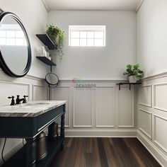 a bathroom with white walls and wood flooring next to a black counter top sink