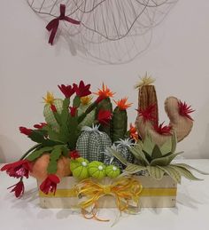 an arrangement of cactus and succulents in a wooden box