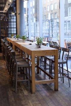 an empty restaurant with tables and chairs in front of large windows that look out onto the street