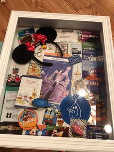 a mickey mouse ear and other items are on display in a shadow box at disney world