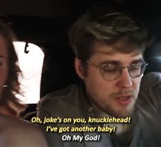 a man and woman sitting in the back seat of a car talking to each other