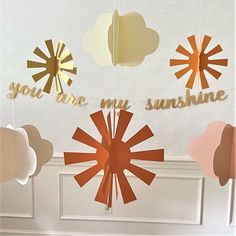 some paper decorations are hanging from the ceiling in front of a door with words that say you are my sunshine