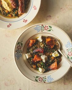 two bowls filled with food on top of a table